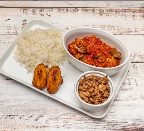 a hearty and flavorful dish featuring steamed rice, seasoned beans, savory stew, and sweet fried plantains